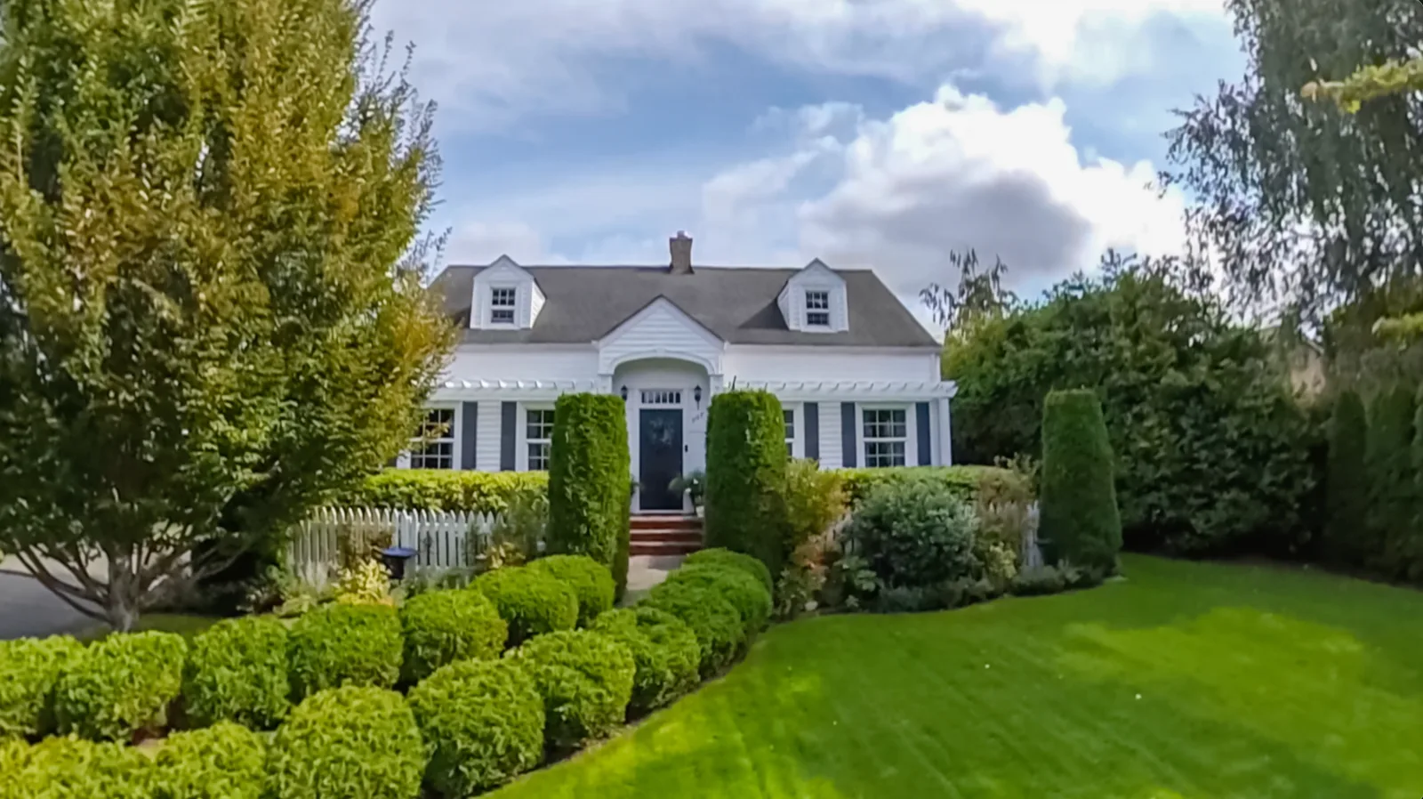 Two-story home with a covered front porch and mown lawn