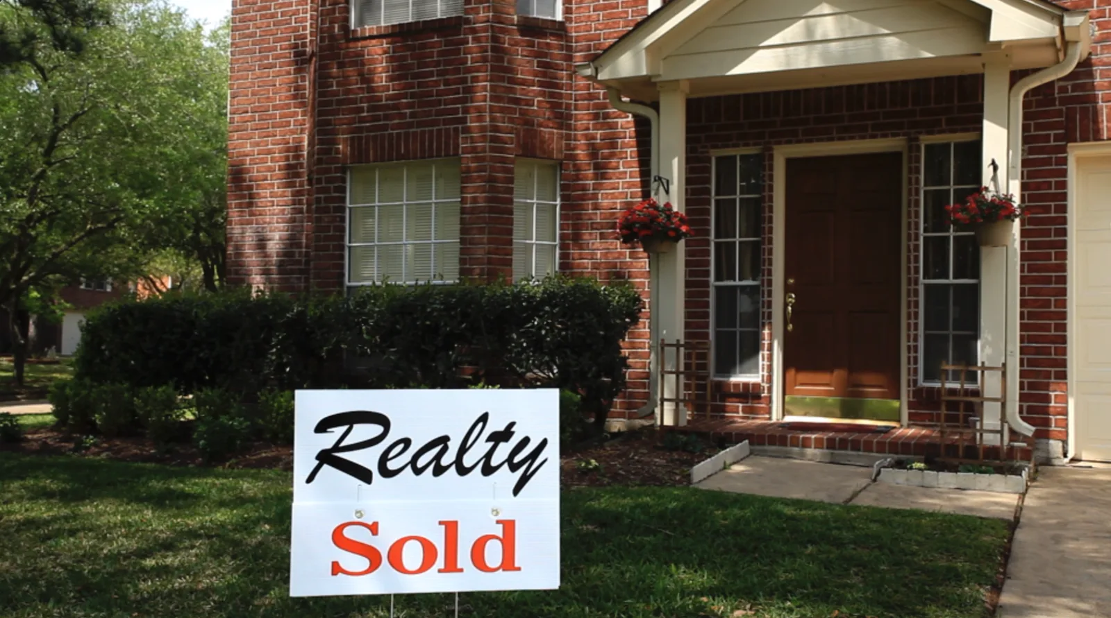 Sold sign in the front yard of a house
